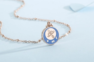 Detailed macro of rose gold Sagittarius pendant with blue enamel and zodiac motifs
