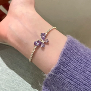 Détail d'un bracelet papillon violet avec chaîne de tennis en zircon au poignet