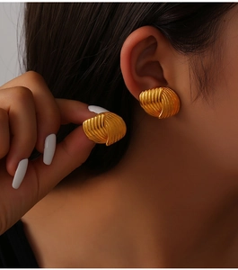 Detail of 18K gold plated titanium steel shell texture earrings worn by a model