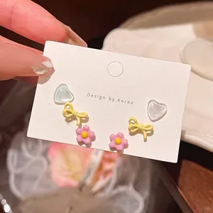 Detailed view of S925 silver stud earring set with resin heart and bow designs