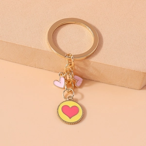 Detail showing pink heart pendants and golden metal charms for backpacks