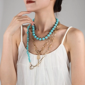 Detailed layered necklace featuring turquoise beads, irregular stones, and gold chain