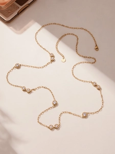 Detailed close-up of a gold-plated stainless steel necklace with sparkling zircon crystals