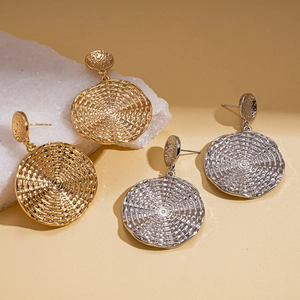 Textured geometric gold and silver hoop earrings with a metallic woven spiral pattern