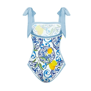 Detail of Mediterranean lemon print and bow shoulder ties on a blue one-piece swimsuit