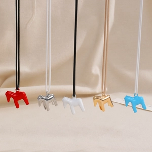 Dettaglio di ciondoli a forma di cavallo in smalto colorato rosso, argento, bianco e oro