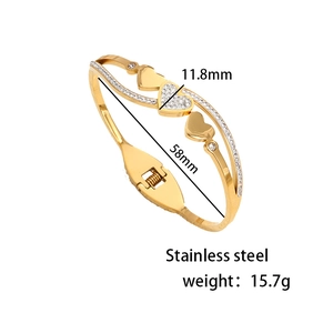 Polished stainless steel heart bangle with crystal accents and spring opening design