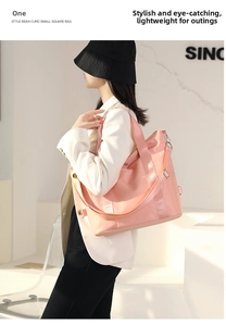 Pink waterproof nylon tote bag with wide strap worn by model in a minimalist setting