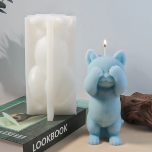 Détail du moule en silicone chat mignon et d'une figurine de chaton bleu sur un livre vert