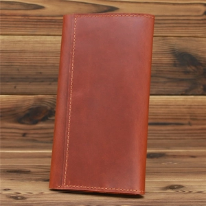Detailed view of vintage crazy horse leather wallet texture and stitching on wood back