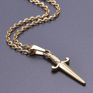 Close-up of golden stainless steel dagger pendant necklace with 18k gold plating details