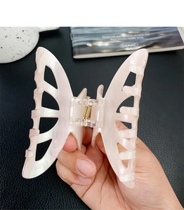 Detail of elegant pearl pink mermaid tail hair claw with butterfly cutout design