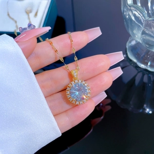 Detailed macro view of gold titanium steel necklace featuring a large cubic zirconia pendant