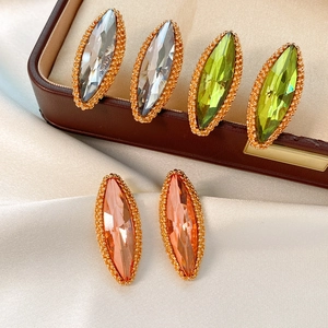 Detailed macro view of marquise-cut crystal earrings in white, green and orange colors