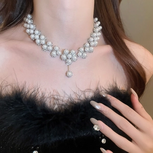 Close-up of elegant floral pearl necklace with sparkling rhinestones on a model