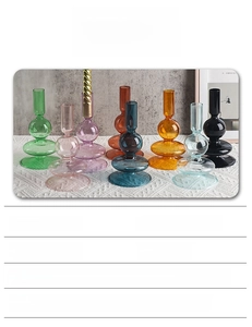 Colorful high borosilicate glass candle holders in geometric shapes on a white tablecloth