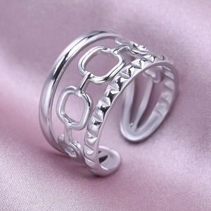 Detail of vintage silver 304 stainless steel layered open ring on purple silk fabric
