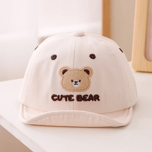Gros plan sur la casquette beige pour bébé avec broderie ours et visière souple