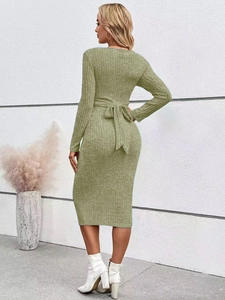 Detail of green knitted maternity dress featuring long sleeves and ribbed texture