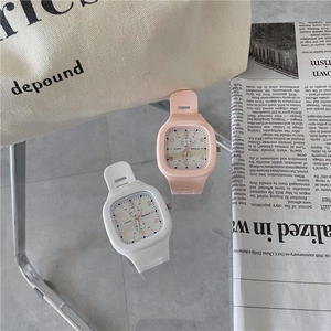 Close-up of pink and white square silicone watches on a casual lifestyle background