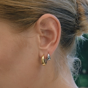 Model trägt zweifarbige klobige Creolen aus 18K Gold und Silber im luxuriösen Seitenprofil