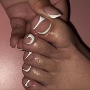 Detailed view of white French tip press-on toenails for a professional pedicure look