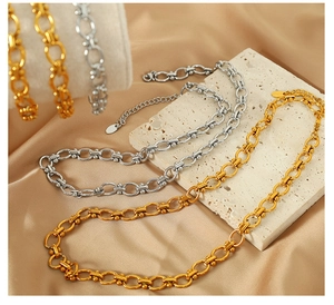 Detailed view of gold and silver layered link necklaces with adjustable clasps on silk