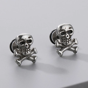 Detail of silver gothic skull stud earrings with punk cross sword and rhinestone accents