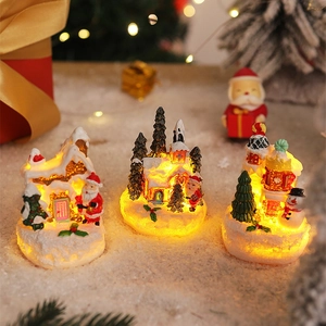 Three illuminated Christmas resin gingerbread houses with snowy details and warm LED lights