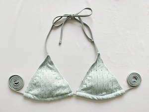 Detailansicht eines hellgrünen Bikini-Oberteils mit Texturstrick und Nackenbindern