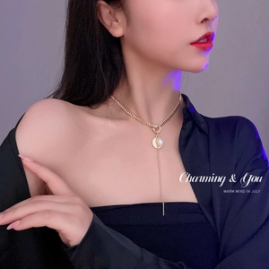 Elegant model wearing a pearl choker necklace with a diamond-set round pendant and T-clasp