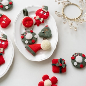 Handmade felt Christmas tree and wreath accessories on a white plate for DIY crafts
