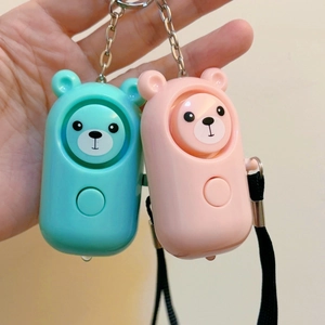 Handheld view of pink and teal bear personal alarms with metal keychain for safety