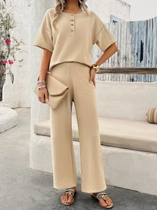 Detail of khaki short sleeve knit button top and wide leg pants in Mediterranean resort style