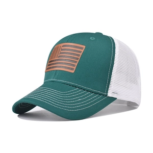 Cappellino trucker verde scuro con rete bianca e patch bandiera USA in pelle su bianco