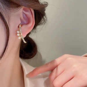 Elegant gold curved ear cuff featuring sparkling rhinestones and three white pearls