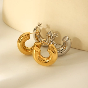 Detailed view of chunky C-shape hoop earrings in polished gold and silver finishes