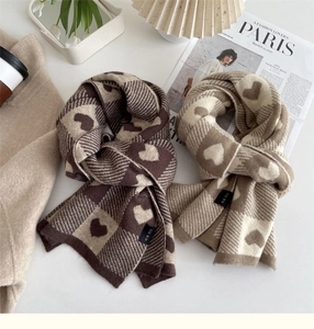 Close-up of heart pattern knitted scarves in coffee and beige on a stylish table
