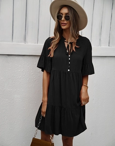 Détails d'une robe noire à manches courtes avec col en V et jupe à plusieurs niveaux