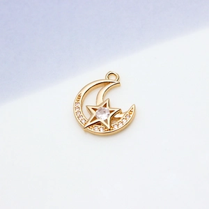 Detailed macro view of gold star and moon jewelry pendant with cubic zirconia inlay