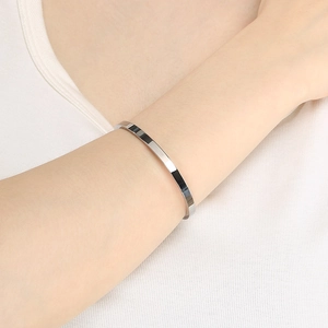 Polished silver stainless steel cuff bangle bracelet on model's wrist close-up view