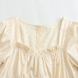 Robe beige élégante avec encolure carrée, manches bouffantes et tissu jacquard plissé