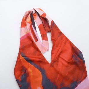 Detail of deep V-neckline and halter ties on a vibrant watercolor floral print dress