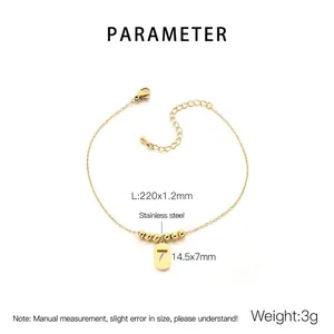 Detail of gold titanium steel anklet with number 7 pendant and beads on white background
