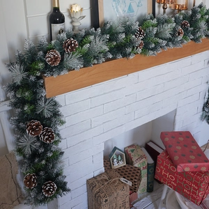 Close-up of frosted Christmas garland with pine cones on a cozy white mantel decoration