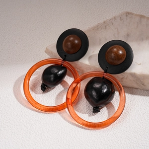 Détail de boucles d'oreilles géométriques vintage avec perles en bois et résine orange