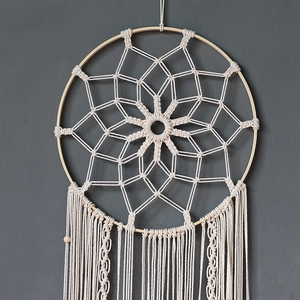 Detail showing handwoven cotton macrame dreamcatcher with floral grid and wooden bead