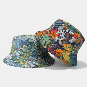 Double-sided reversible bucket hat with floral and tropical leaf patterns for sun protection