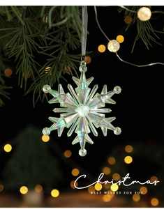 Macro view of iridescent acrylic snowflake ornament with sparkling silver ribbon