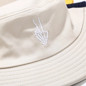 Beige bucket hat with white skeleton finger embroidery on high quality canvas fabric
